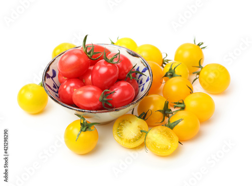 yellow and red cherry tomatoes on white background.