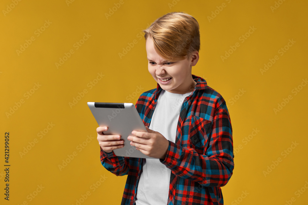 child boy in checkered shirt using digital tablet child boy in checkered shirt using digital tablet