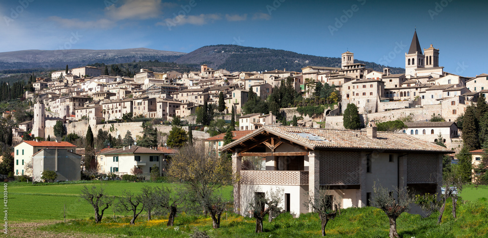 Spello. Perugia. Skyline del borgo con prato e casa colonica da sud