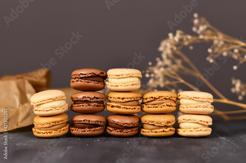 Stacks of natural brown, beige and cream colored French macarons with coffee, mocha, chocolate and vanilla flavour  photo