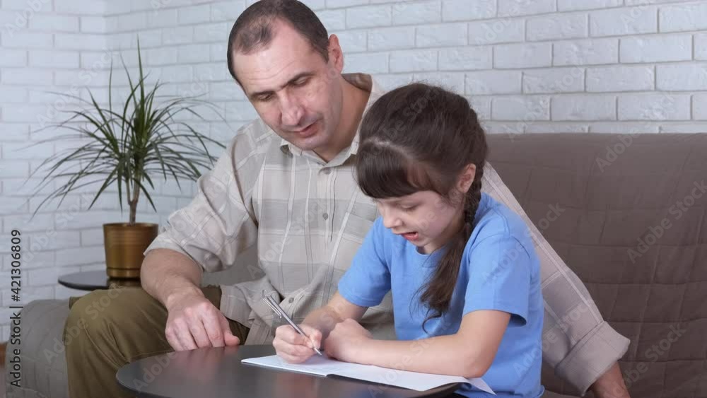 Education help with father. A father give an educational help to her daughter. A concept of self education on distance at home. Education help with father. A father give an educational help to her daughter. A concept of self education on distance at home.
