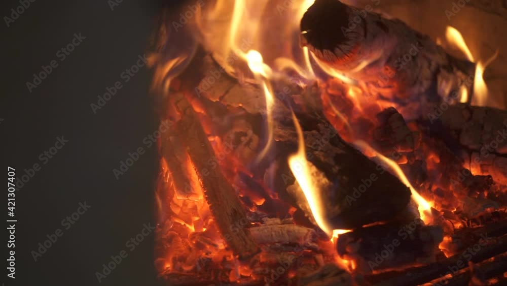 Firewood burns in the fireplace at home. New year festive mood, cozy and hygge concept. Firewood burns in the fireplace at home. New year festive mood, cozy and hygge concept.