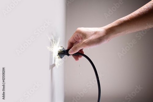Wet hand connecting electrical plug cause electric shock, Idea for causes of home fire, Electric short circuit, Electrical hazard can ignite household items, Residential building electrical fires.