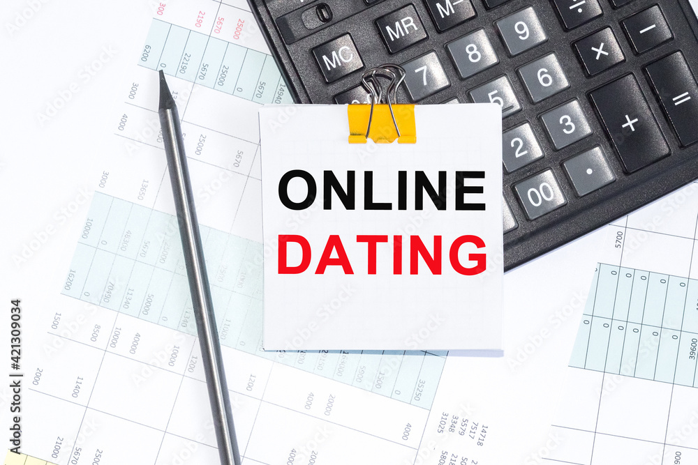 Text ONLINE DATING on NOTEBOOK ,NOTEBOOK, CALCULATOR PENCIL on white background. Text ONLINE DATING on NOTEBOOK ,NOTEBOOK, CALCULATOR PENCIL on white background.