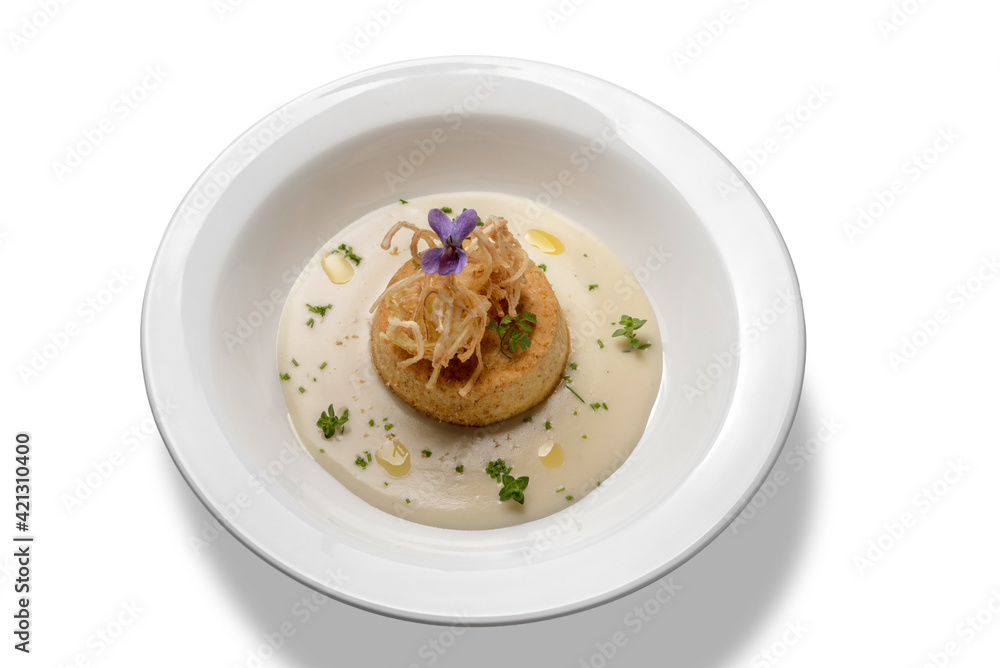 savory flan of leeks in cream cheese and olive oil, in white plate isolated on white, top view