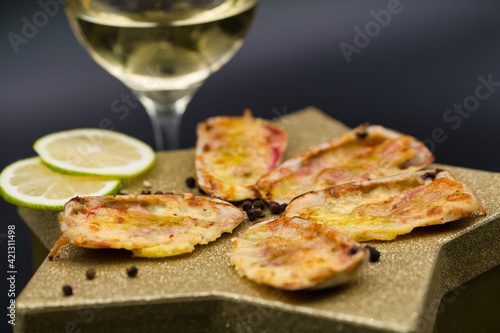 (machas a la parmesana) seashell cooked in parmesan. served on a golden star