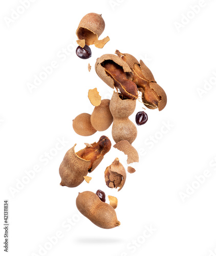 Crushed tamarind fruits are falling down on white background photo