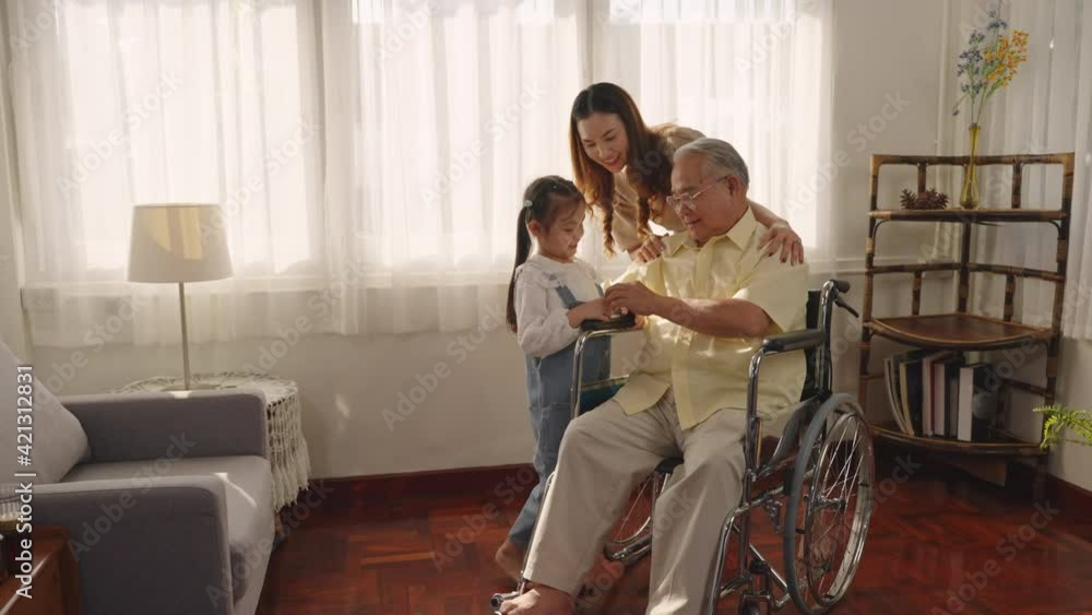 Granddaughter plays with grandpa on a wheelchair. Joyfully the two smiled and happily hugged. Asian Thai family granddaughter and grandfather playing paper birds. tease, laugh and cheer, Retirement, Granddaughter plays with grandpa on a wheelchair. Joyfully the two smiled and happily hugged. Asian Thai family granddaughter and grandfather playing paper birds. tease, laugh and cheer, Retirement,