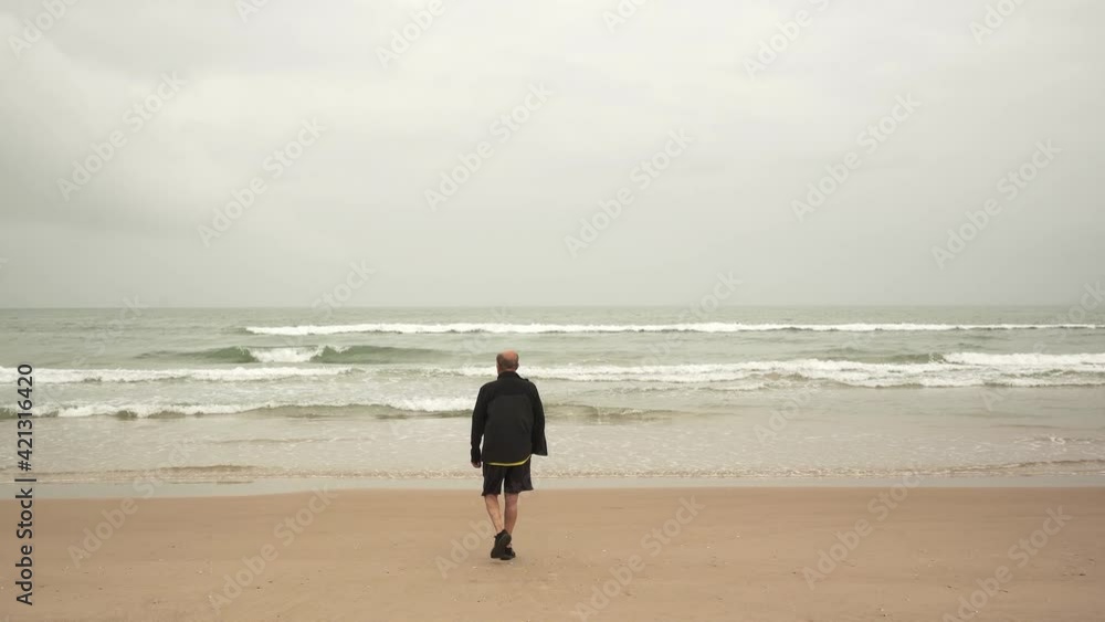 Senior male athlete walking near sea Senior male athlete walking near sea