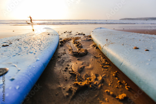 Canvas Print Surfboards in sand and water at sunset on the ocean coast of Portugal on Baleal