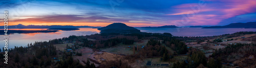 Aerial Panoramic View of a Beautiful Sunrise Over Lummi Island  Washington. Drone shot of the south end of the island with Bellingham Bay  Orcas Island and Mt. Baker in the background. 