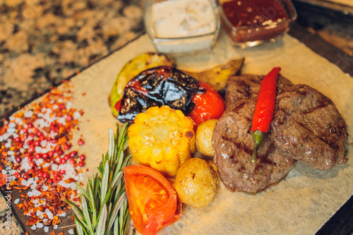 grilled seiki on a wooden board with potato sauce and vegetables. photo