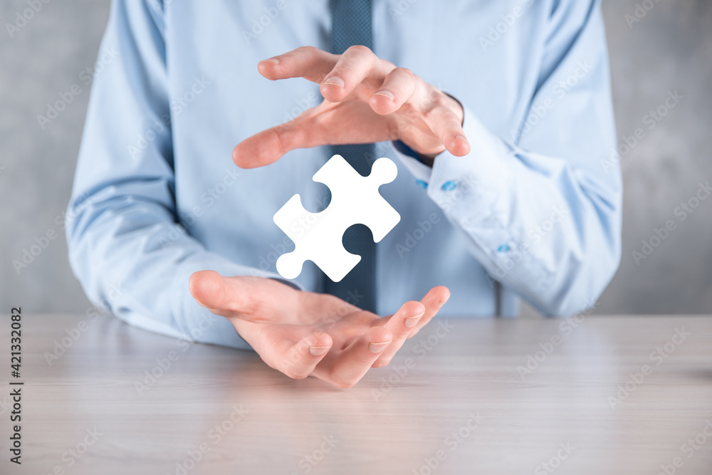 Businessman holds a piece of puzzle jigsaw in his hands.The concept of cooperation, teamwork, help and support in business.