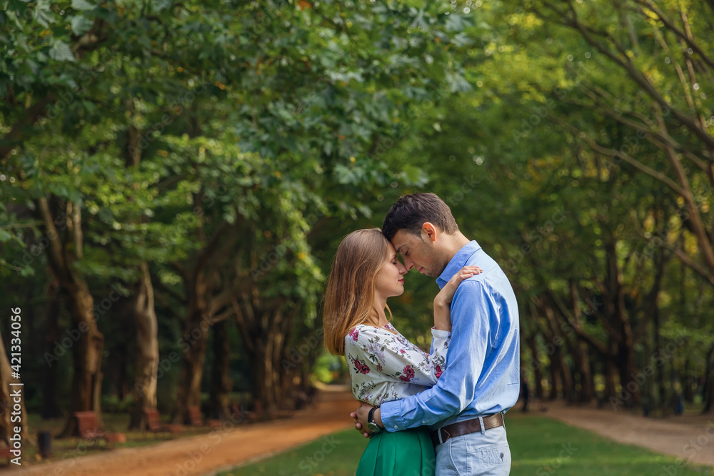 Fototapeta premium Handsome young man hugging with a woman during summer vacation in nature.