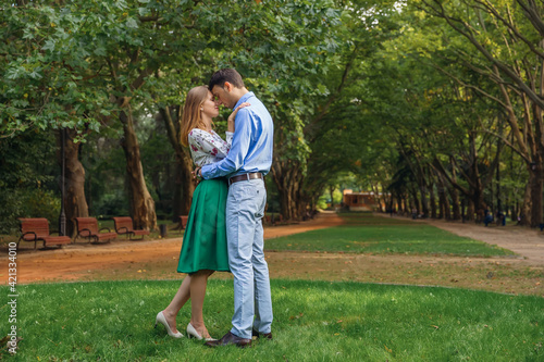 Happy romantic moments of lovely couple hugging in the park whil