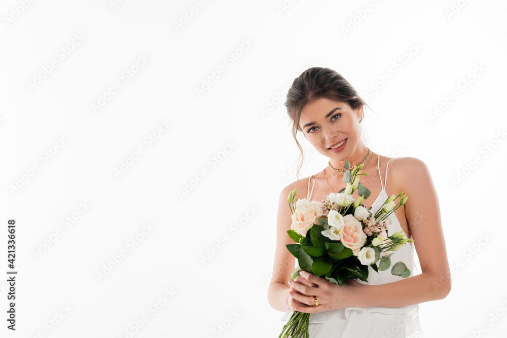 smiling bride with wedding bouquet looking at camera isolated on white