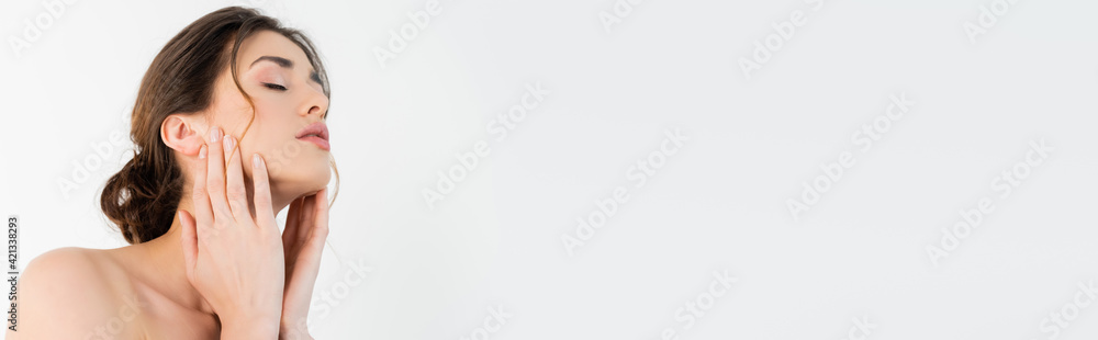 sensual woman touching face while posing with closed eyes isolated on grey, banner