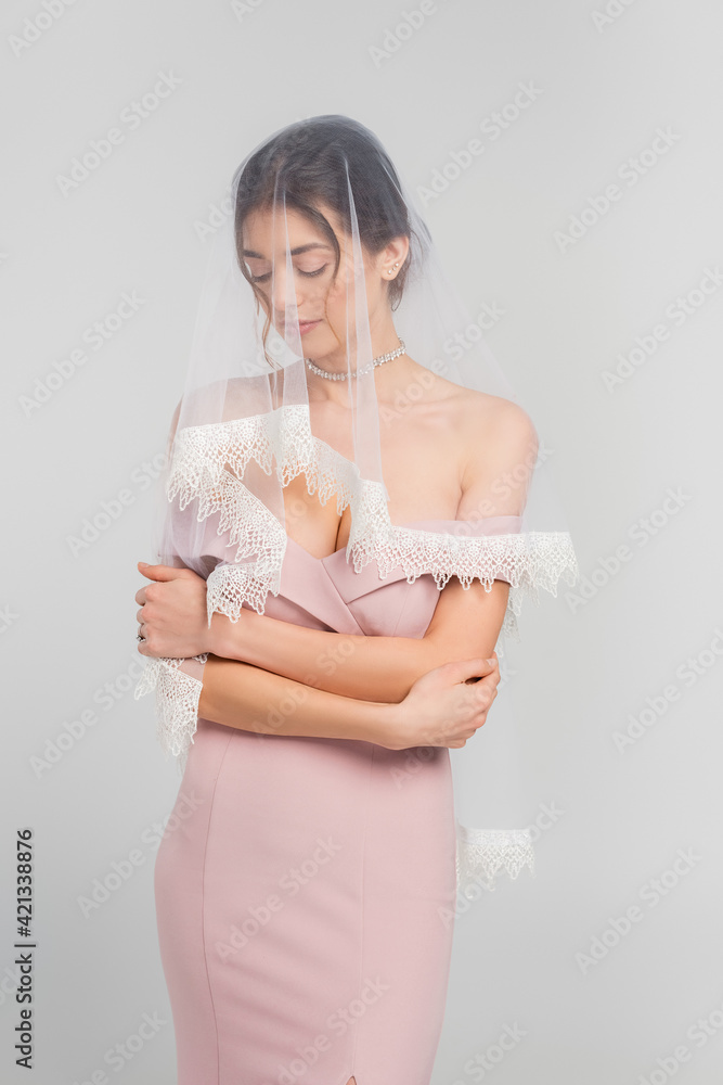 sensual woman in elegant dress and veil standing with closed eyes isolated on grey sensual woman in elegant dress and veil standing with closed eyes isolated on grey