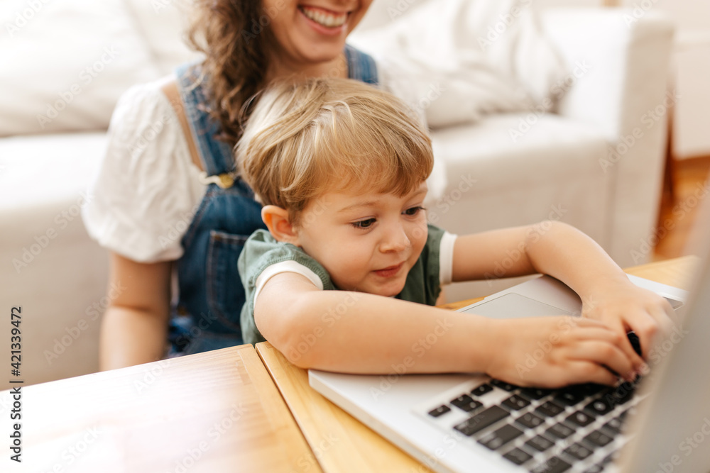 Boy learning using laptop with mom at home Boy learning using laptop with mom at home