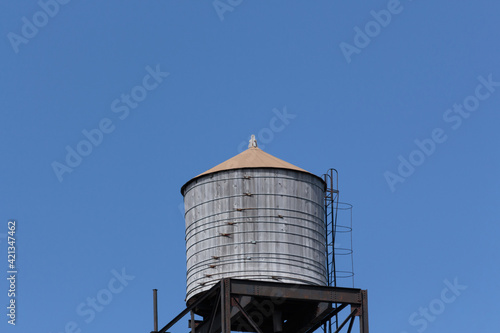 rooftop water tank against a clear blue sky with copy space.