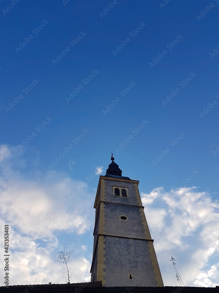 Churche tower against blue sky and clouds