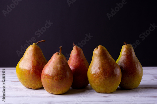 Ripe pears on a wooden table are collected in a group