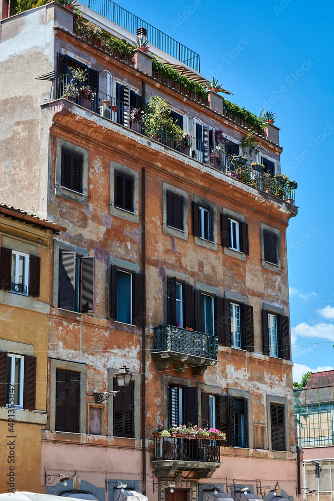 A view of facade of generic picturesque roman building with aged walls on the streets of Rome, Italy.