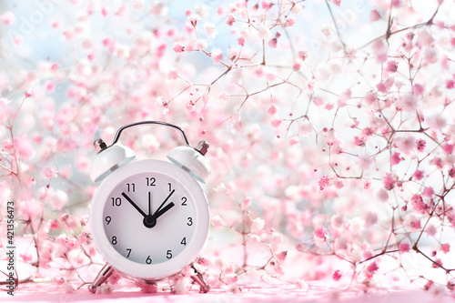 Alarm clock with light and airy spring blossoms background