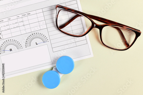 Fotografie Medical eyeglass prescription with parameters, glases and contact lens container