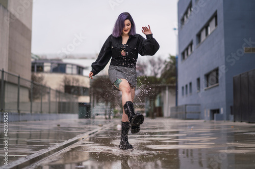 Chica con pelo morado interactuando con el smartphone y con la lluvia