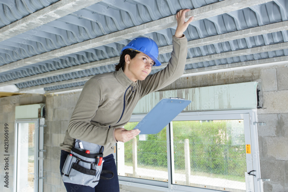 female engineer in hard hat checking ceiling air ventilation female engineer in hard hat checking ceiling air ventilation