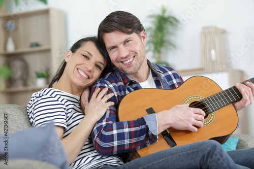 happy couple on the sofa with a guitar