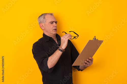 senior man looking at documents with difficulty
