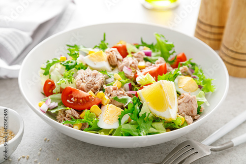 Tuna salad with boiled egg, tomato, lettuce, corn and red onion. Healthy and detox food concept. Ketogenic diet. Fresh vegetable salad bowl on white background