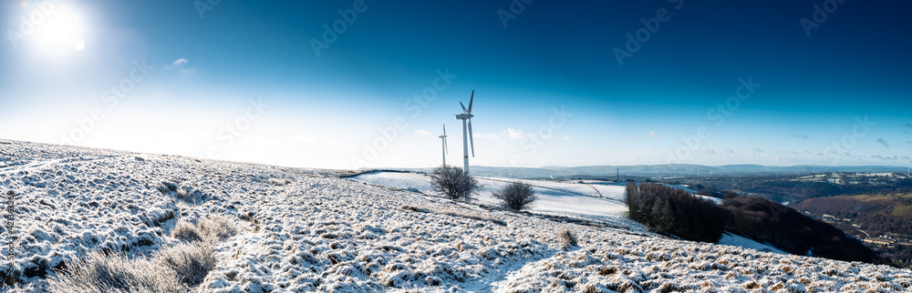 panoramic view of Wind turbines during Morning sunrise in a winter wonderland south wales uk panoramic view of Wind turbines during Morning sunrise in a winter wonderland south wales uk