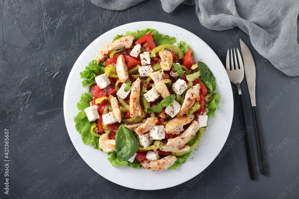 Salad with bulgur, baked chicken, bell pepper, basil and feta on a white plate. Closeup. Horizontal format Salad with bulgur, baked chicken, bell pepper, basil and feta on a white plate. Closeup. Horizontal format