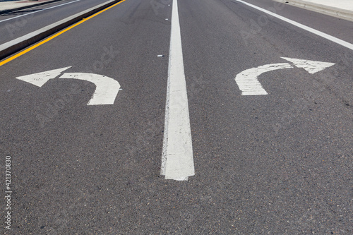 Directional arrows pointing left and right painted on a highway.