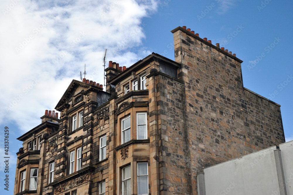 19th Century Stone Tenement Building seen from Below against Blue Sky