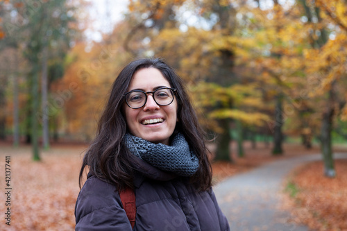 person in autumn park, smiling woman in an autumn forest