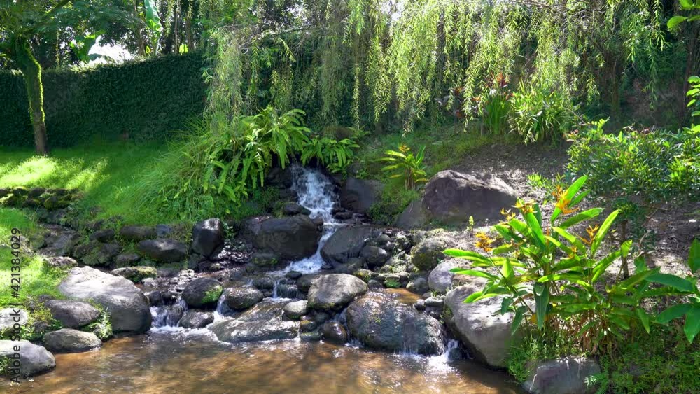Beautiful artificial waterfall in peaceful tropical garden Beautiful artificial waterfall in peaceful tropical garden