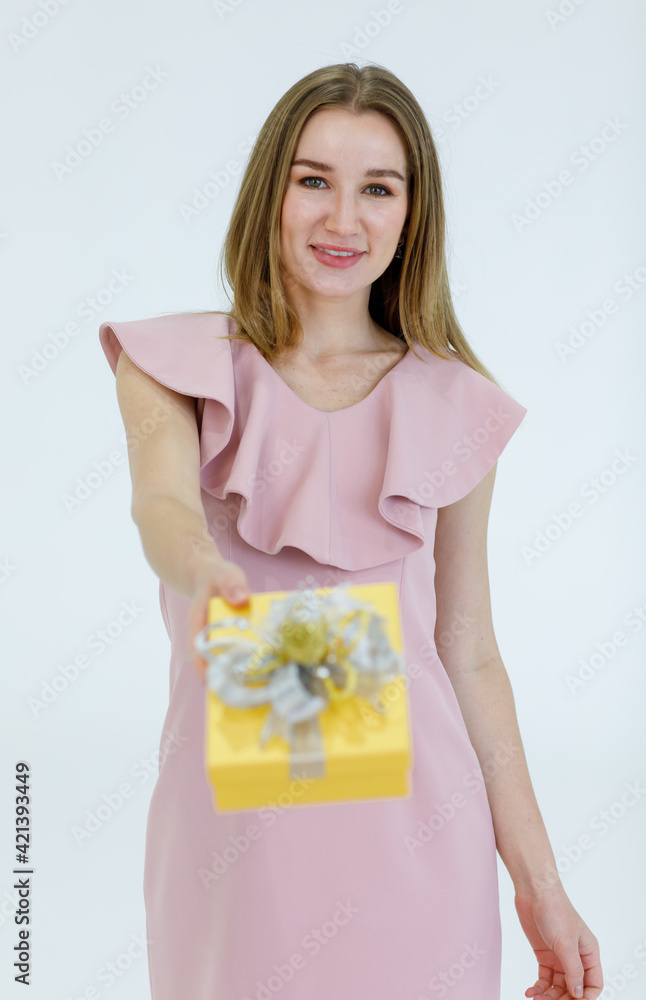 Portrait adult pretty caucasian woman blonde hair and pink dress look at camera holding present show a gift box and smile with white teeth look feel happy in studio with white background Portrait adult pretty caucasian woman blonde hair and pink dress look at camera holding present show a gift box and smile with white teeth look feel happy in studio with white background