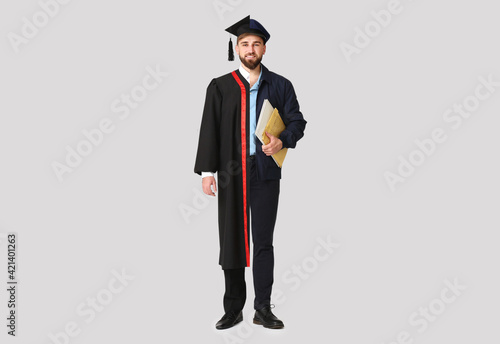 Comparison portrait of young man in bachelor robe and uniform of postman on l...