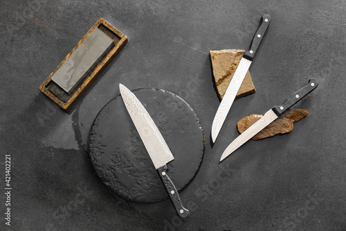 Set of knives with sharpening stones on dark background photo