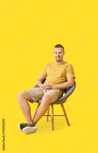 Young man sitting in armcha...
