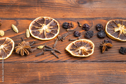 Spices, cloves, anise, orange lie on a wooden table