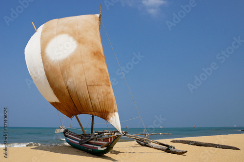 Εκτύπωση καμβά In Negombo, Sri Lanka, an outrigger fishing boat (oru) with a colorful sail rests on the beach, awaiting its next trip out onto the Indian Ocean