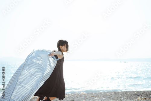 海で布を風に靡かせて遊ぶ女の子