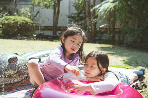 庭に浮き輪を出して遊ぶ姉妹