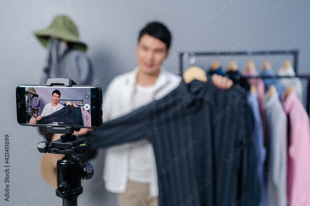 man selling clothes and accessories online by smartphone live streaming, business online e-commerce at home