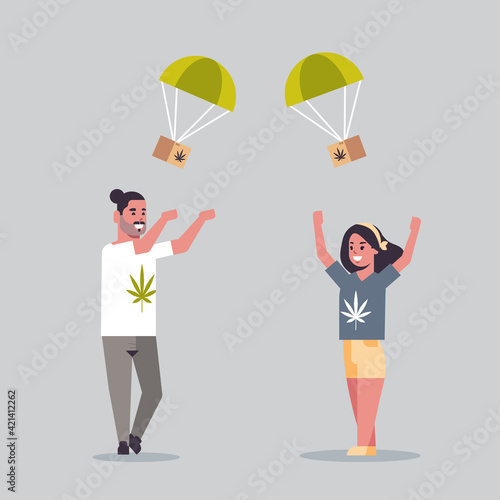 couple catching cannabis parcel box falling down with parachute from sky marijuana air mail express delivery drug consumption concept full length flat